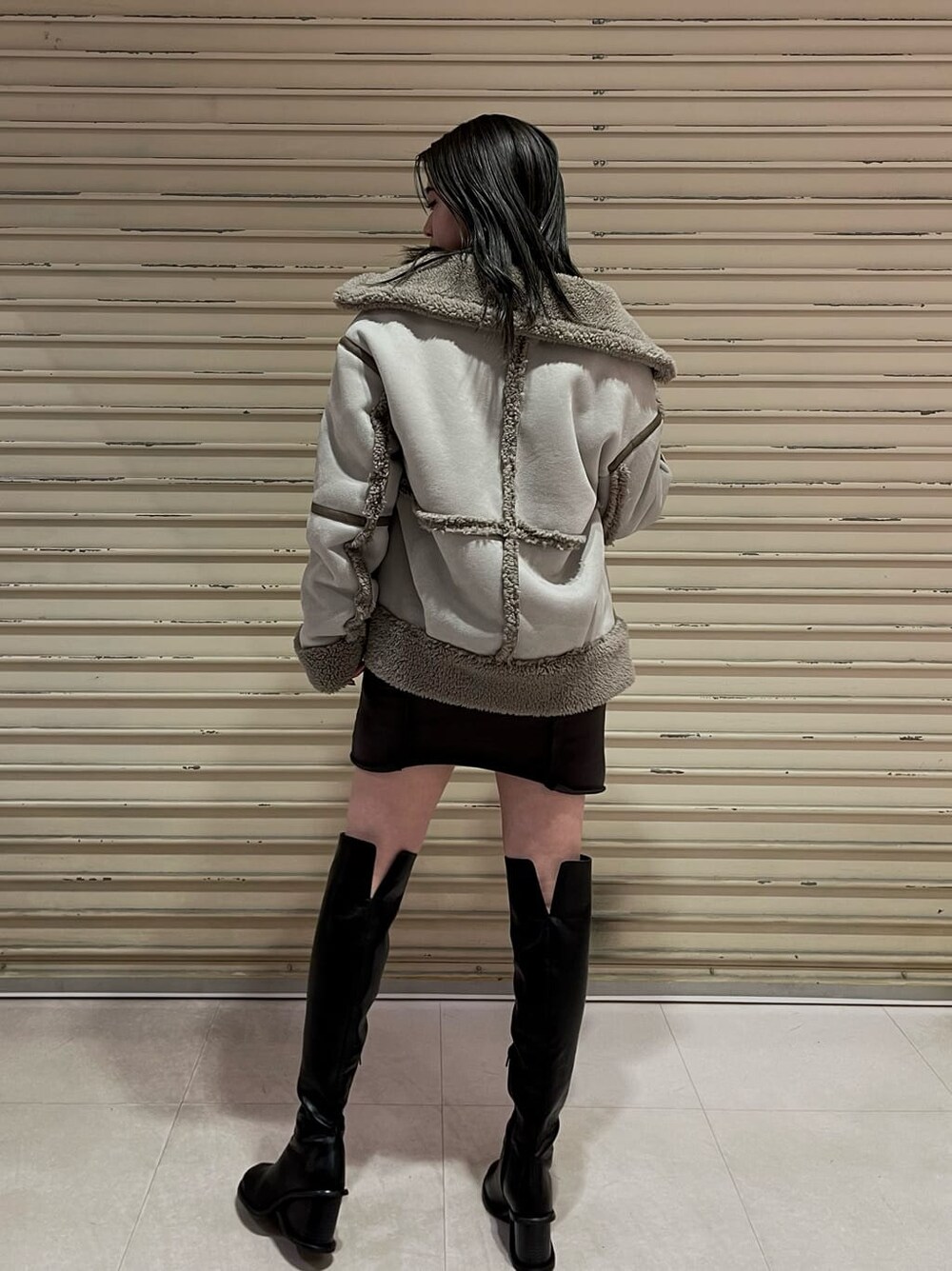 ブラック系のブーツ、グレー系のワンピース、グレー系のムートンコートを着用したレディースの秋コーディネートの6枚目の写真