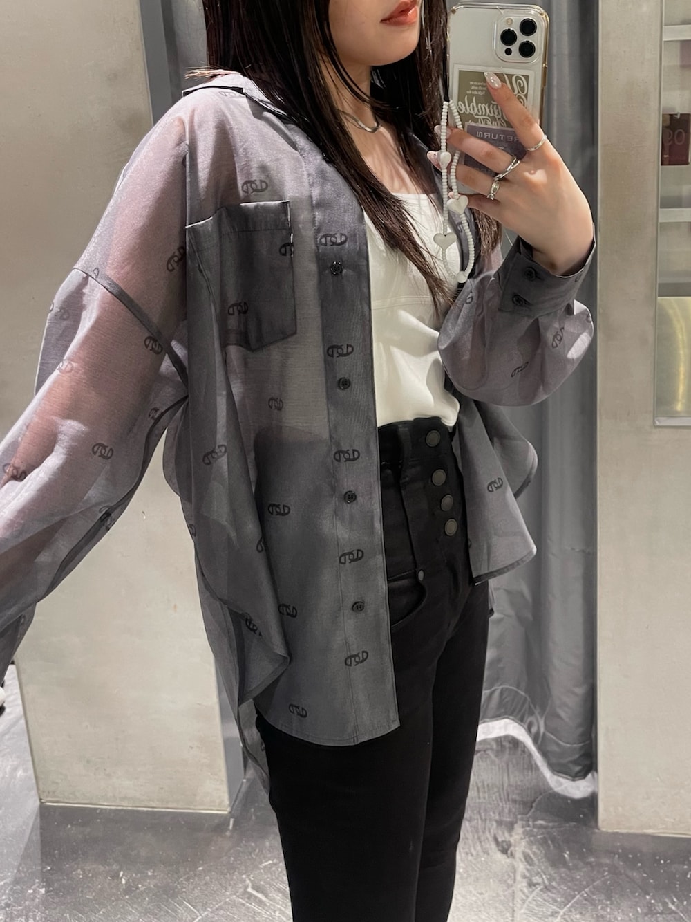 ホワイト系のニット/セーター、ブラック系のシャツ/ブラウス、ブラック系のデニムパンツを着用したレディースの春コーディネートの3枚目の写真