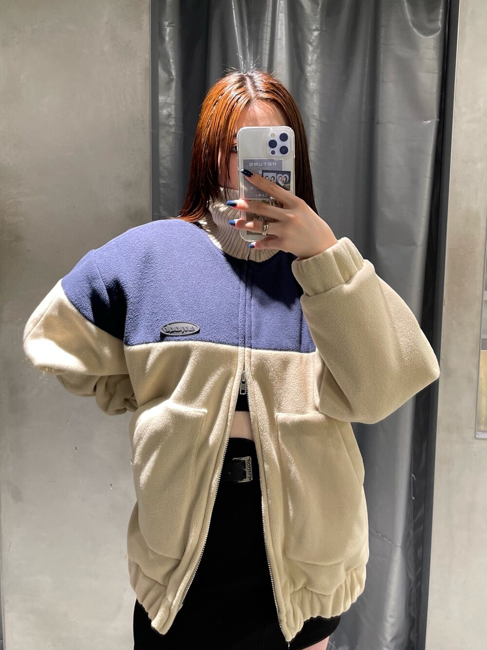 ブルー系のブルゾン、ブラック系のスカート、ブラック系のブーツを着用したレディースの秋コーディネートの4枚目の写真