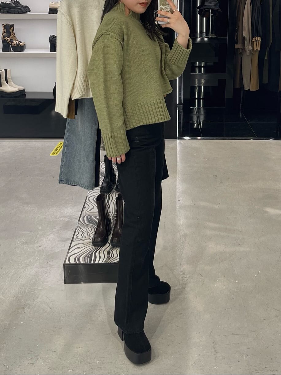 ブラック系のブーツ、ブラック系のデニムパンツ、ベージュ系のニット/セーターを着用したレディースの秋コーディネートの5枚目の写真