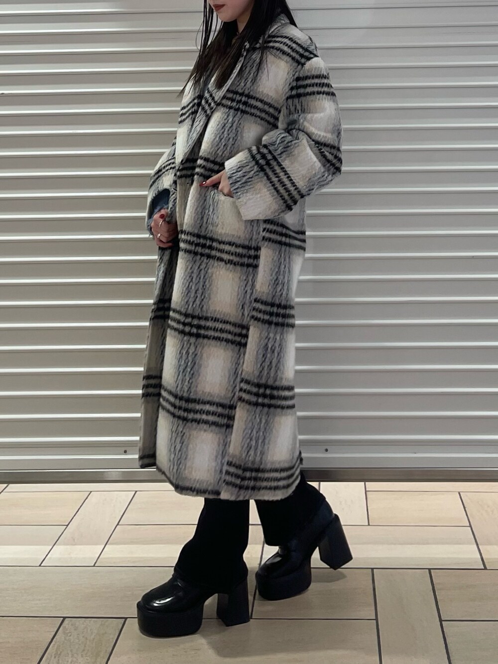 その他のチェスターコート、ブルー系のニット/セーター、ブラック系のデニムパンツを着用したレディースの冬コーディネートの2枚目の写真