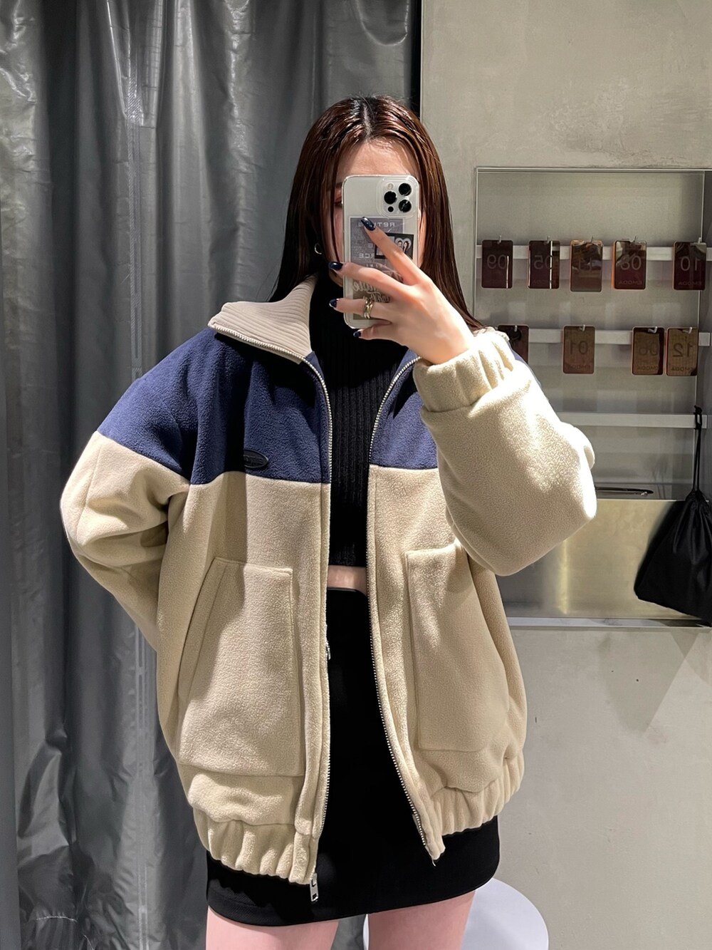 ブルー系のブルゾン、ブラック系のスカート、ブラック系のブーツを着用したレディースの秋コーディネートの3枚目の写真