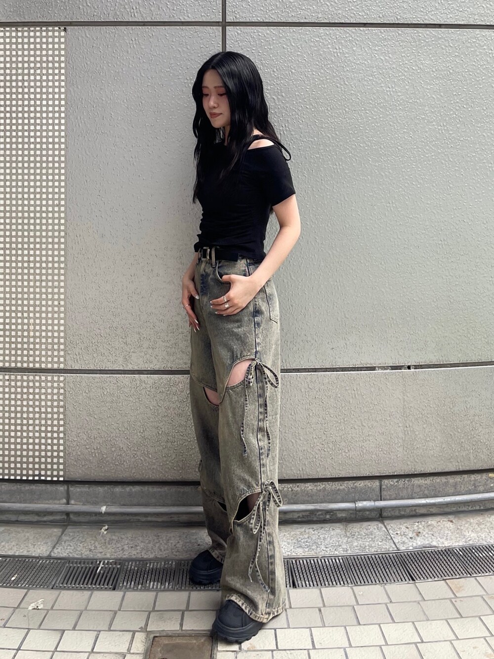 ブルー系のデニムパンツ、ブラック系のTシャツ/カットソー、ブラック系のサンダルを着用したレディースの春コーディネートの3枚目の写真