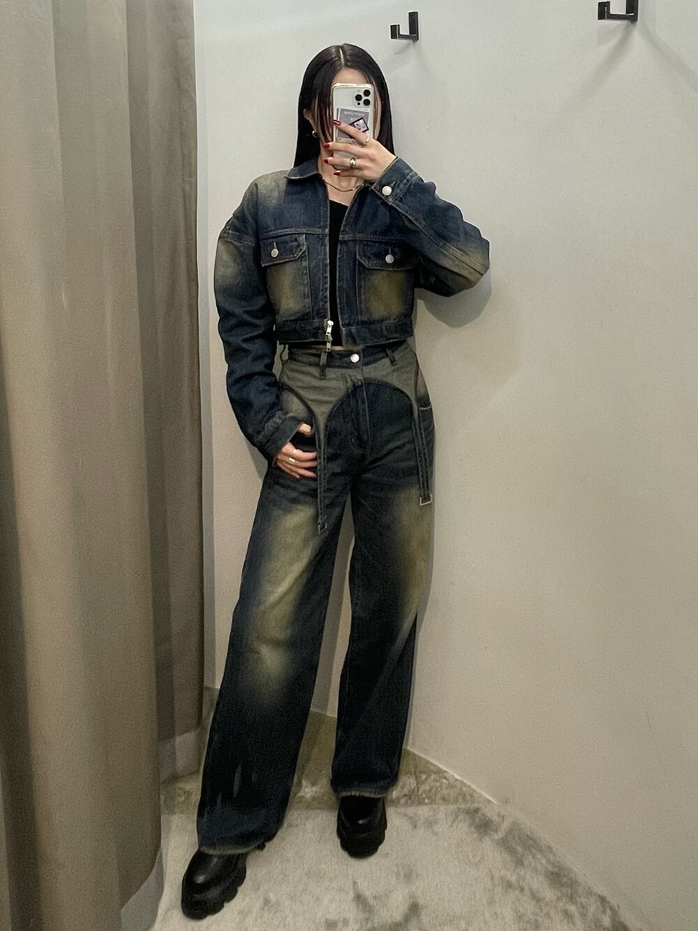 ブルー系のデニムパンツ、ブルー系のデニムジャケット、ブラック系のブーツを着用したレディースの秋コーディネートの2枚目の写真