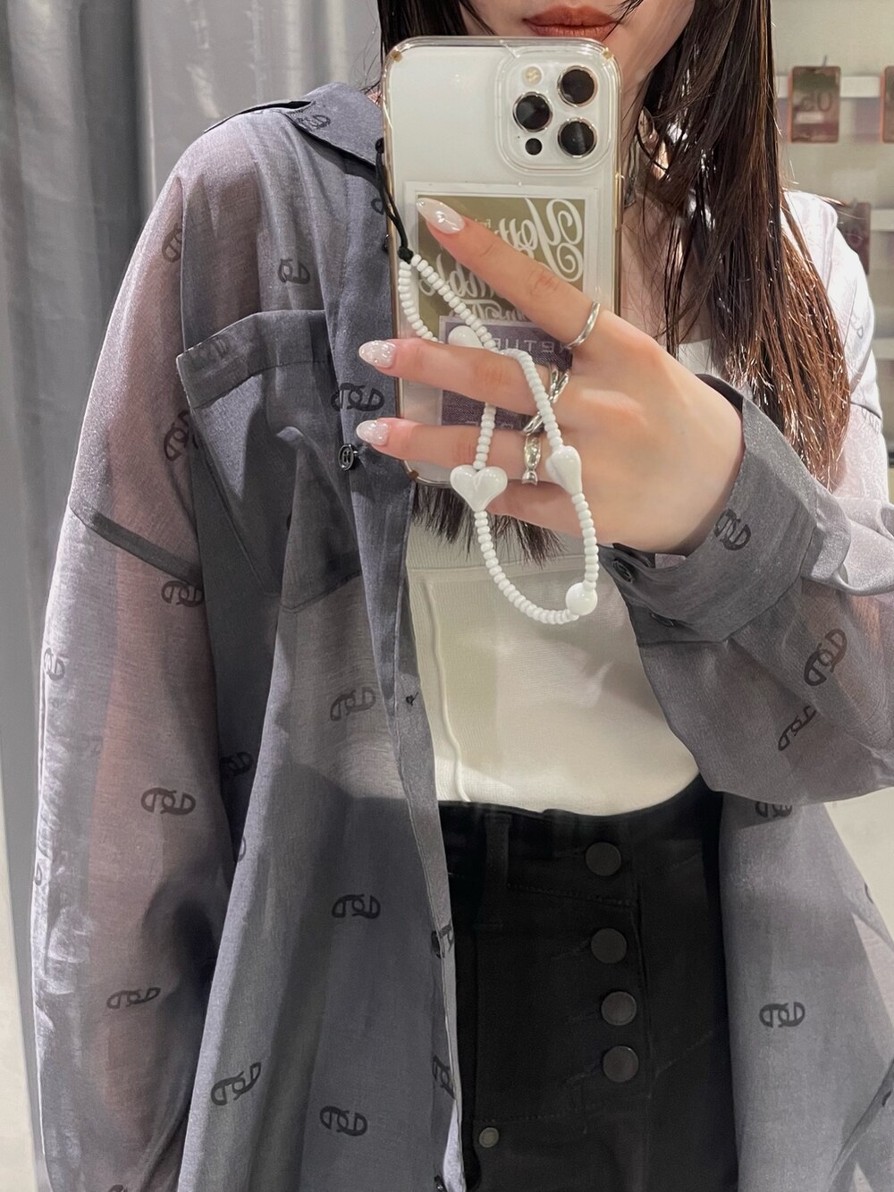 ホワイト系のニット/セーター、ブラック系のシャツ/ブラウス、ブラック系のデニムパンツを着用したレディースの春コーディネートの4枚目の写真