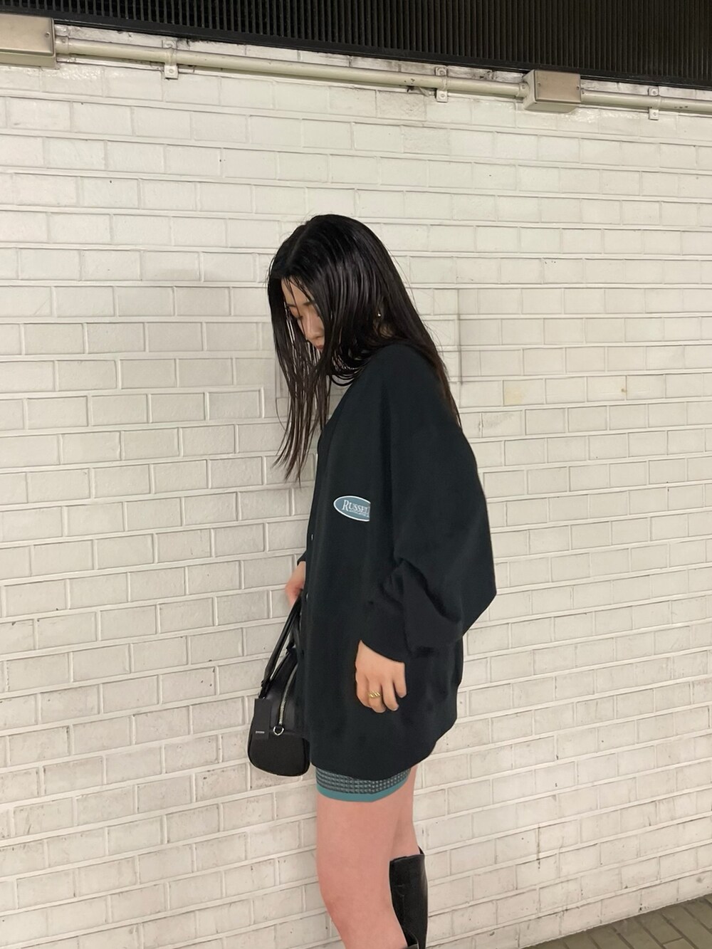 ブラック系のブーツ、ブルー系のスカート、ブラック系のカーディガン/ボレロを着用したレディースの春コーディネートの5枚目の写真