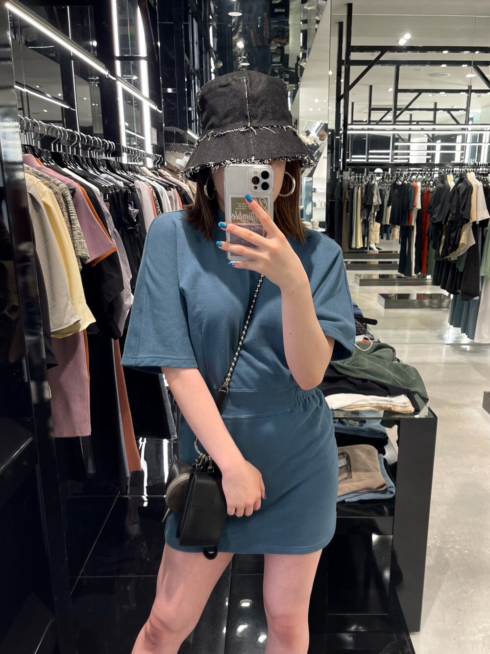 ブルー系のワンピース、ブラック系のサンダル、ブラック系のショルダーバッグを着用したレディースの夏コーディネートの2枚目の写真