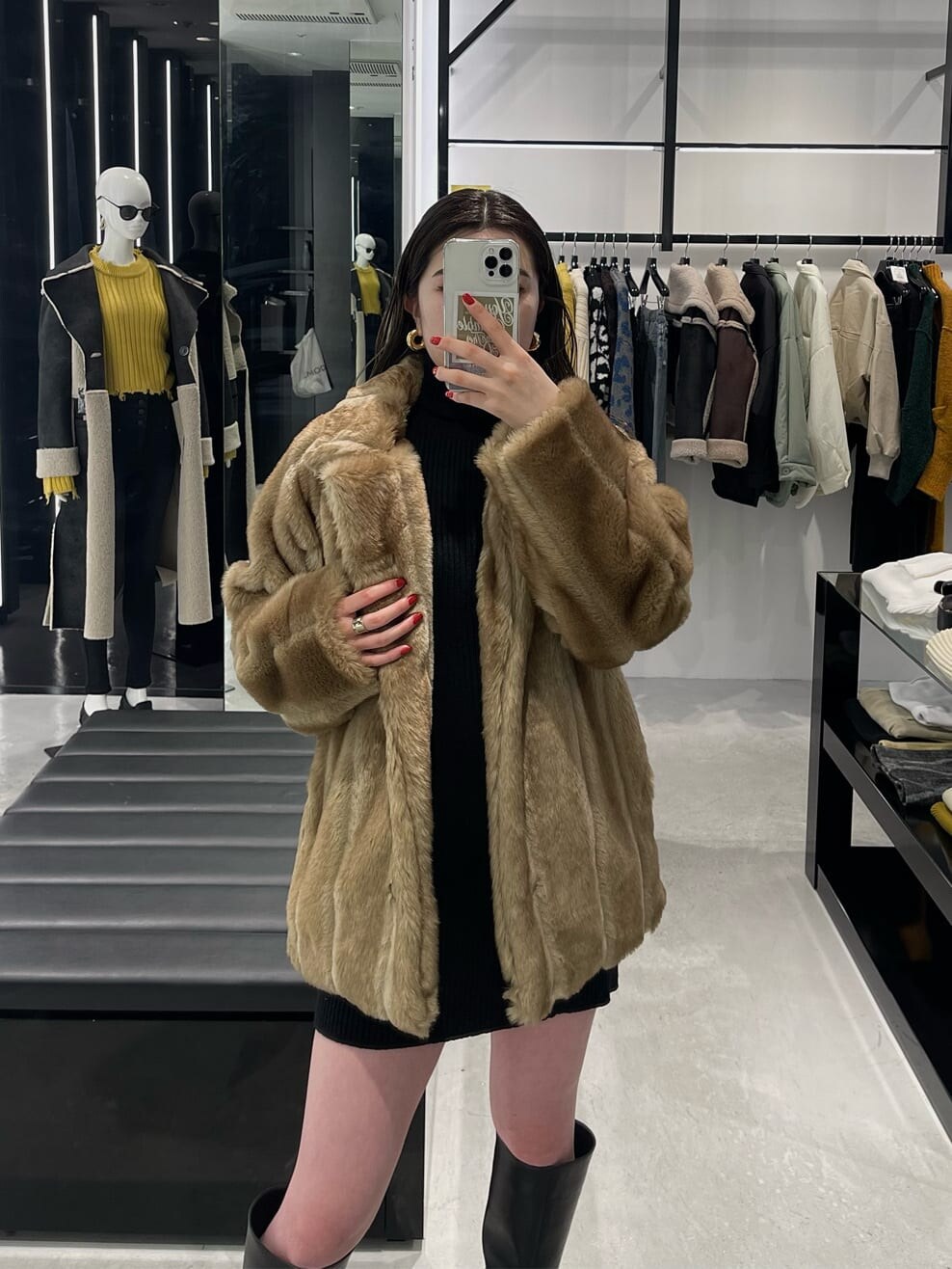 ブラック系のワンピース、ベージュ系のその他アウター、ブラック系のブーツを着用したレディースの冬コーディネートの5枚目の写真