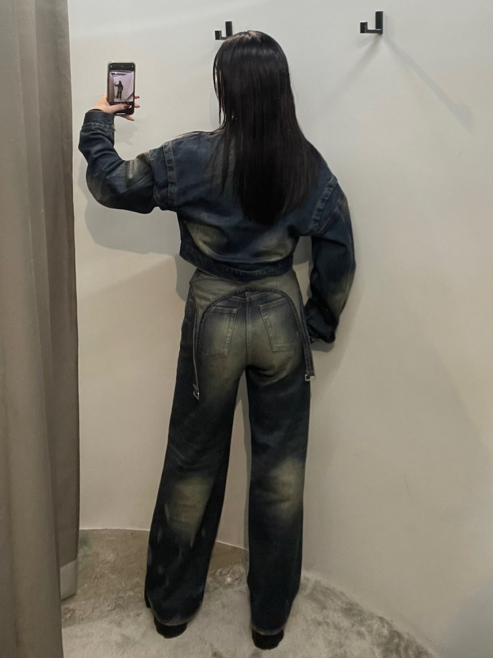 ブルー系のデニムパンツ、ブルー系のデニムジャケット、ブラック系のブーツを着用したレディースの秋コーディネートの4枚目の写真