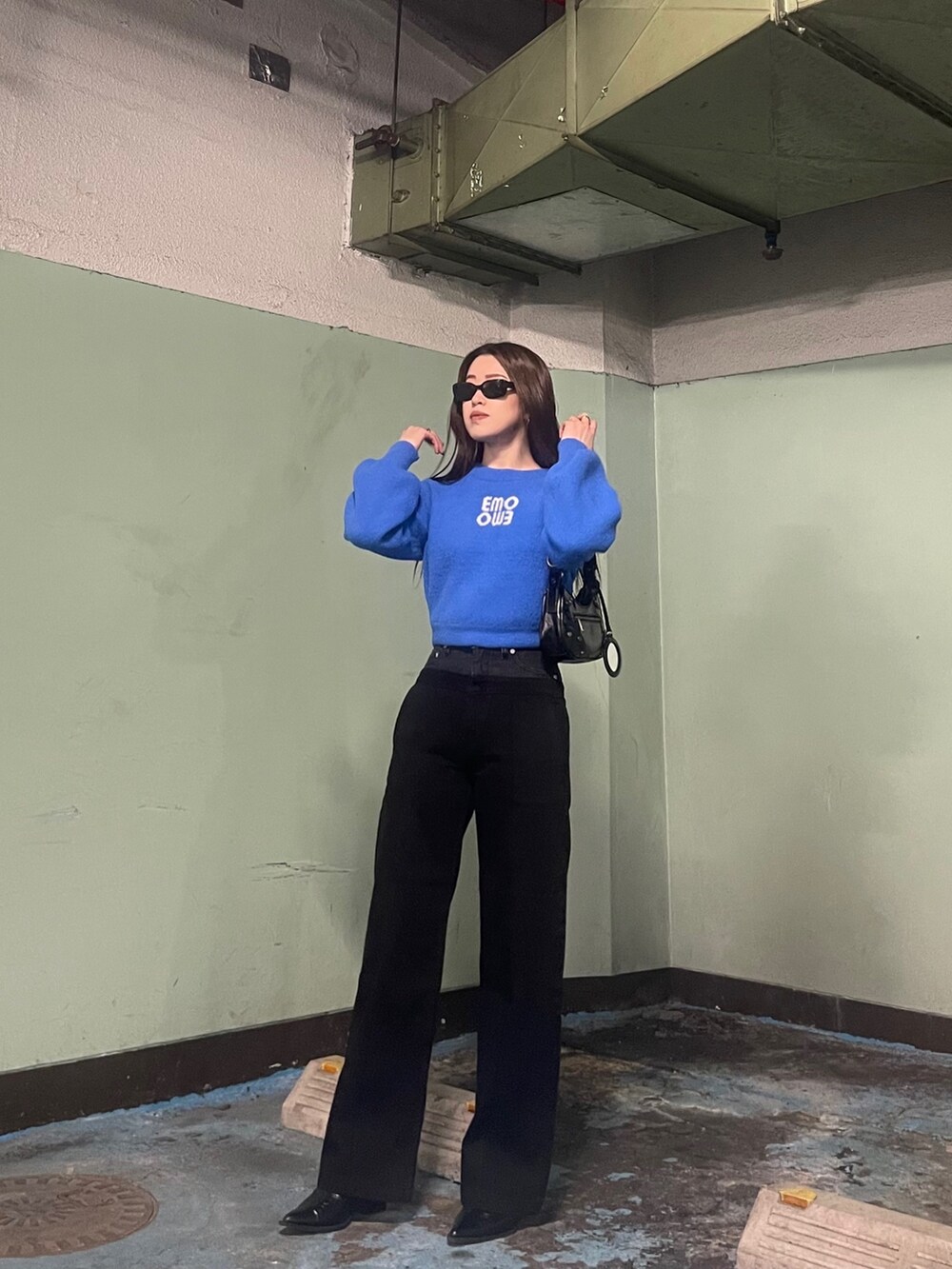 ブルー系のニット/セーター、ブラック系のデニムパンツを着用したレディースの冬コーディネートの2枚目の写真