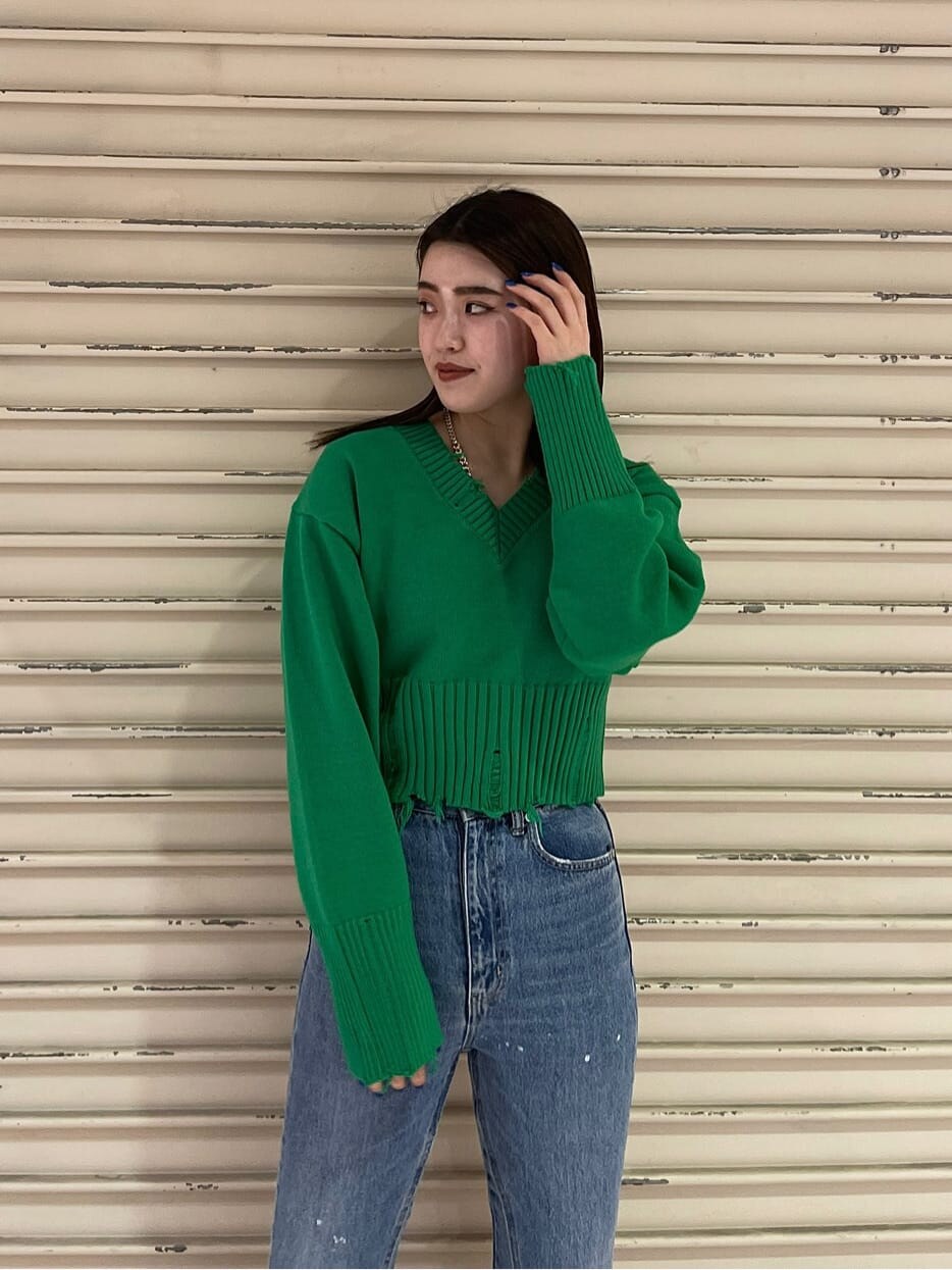 グリーン系のニット/セーターを着用したレディースの冬コーディネートの2枚目の写真