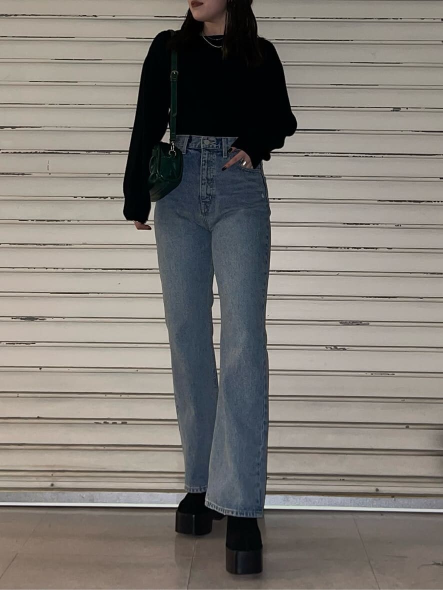 グリーン系のボディバッグ/ウエストポーチ、ブルー系のデニムパンツ、ブラック系のブーツを着用したレディースの秋コーディネートの2枚目の写真