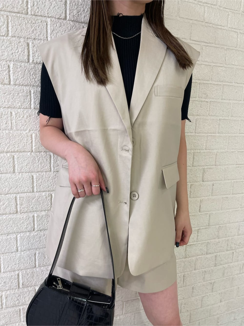 ベージュ系のベスト、ベージュ系のその他パンツ、ブラック系のブーツを着用したレディースの夏コーディネートの4枚目の写真