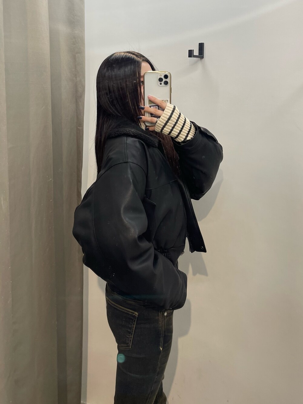 ブルー系のデニムパンツ、ホワイト系のニット/セーター、ブラック系のブルゾンを着用したレディースの秋コーディネートの5枚目の写真