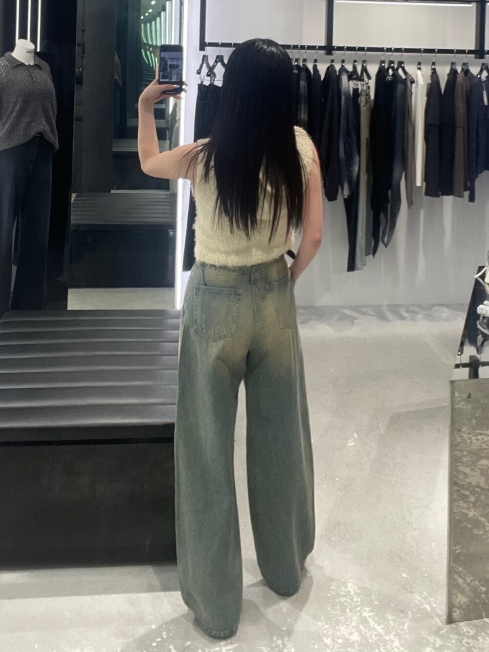 ブルー系のデニムパンツ、ホワイト系のニット/セーターを着用したレディースの春コーディネートの3枚目の写真