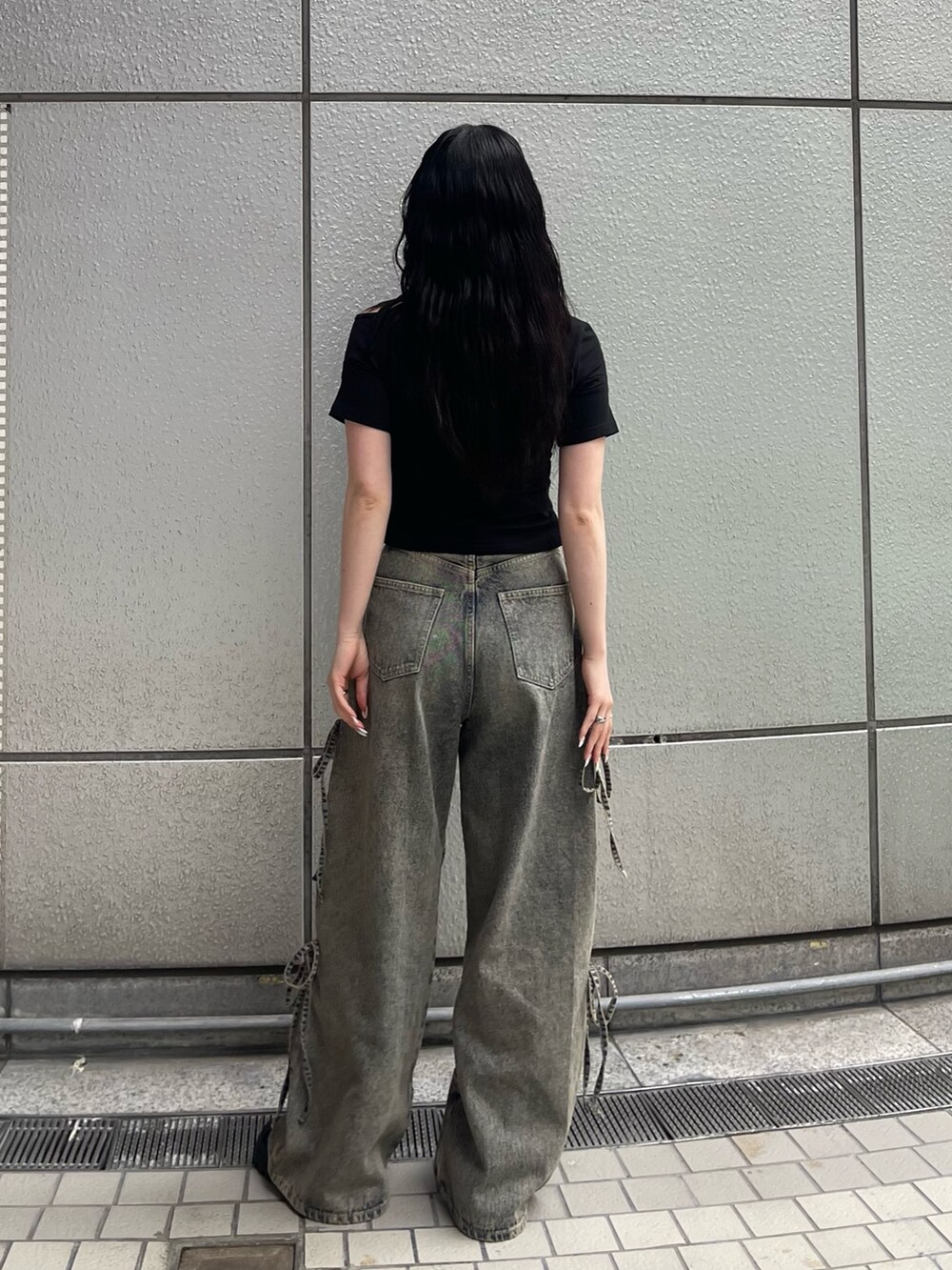 ブルー系のデニムパンツ、ブラック系のTシャツ/カットソー、ブラック系のサンダルを着用したレディースの春コーディネートの5枚目の写真