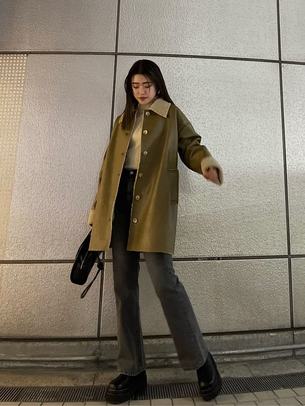 ブラック系のハンドバッグ、ベージュ系のムートンコート、ホワイト系のニット/セーターを着用したレディースの冬コーディネートの4枚目の写真