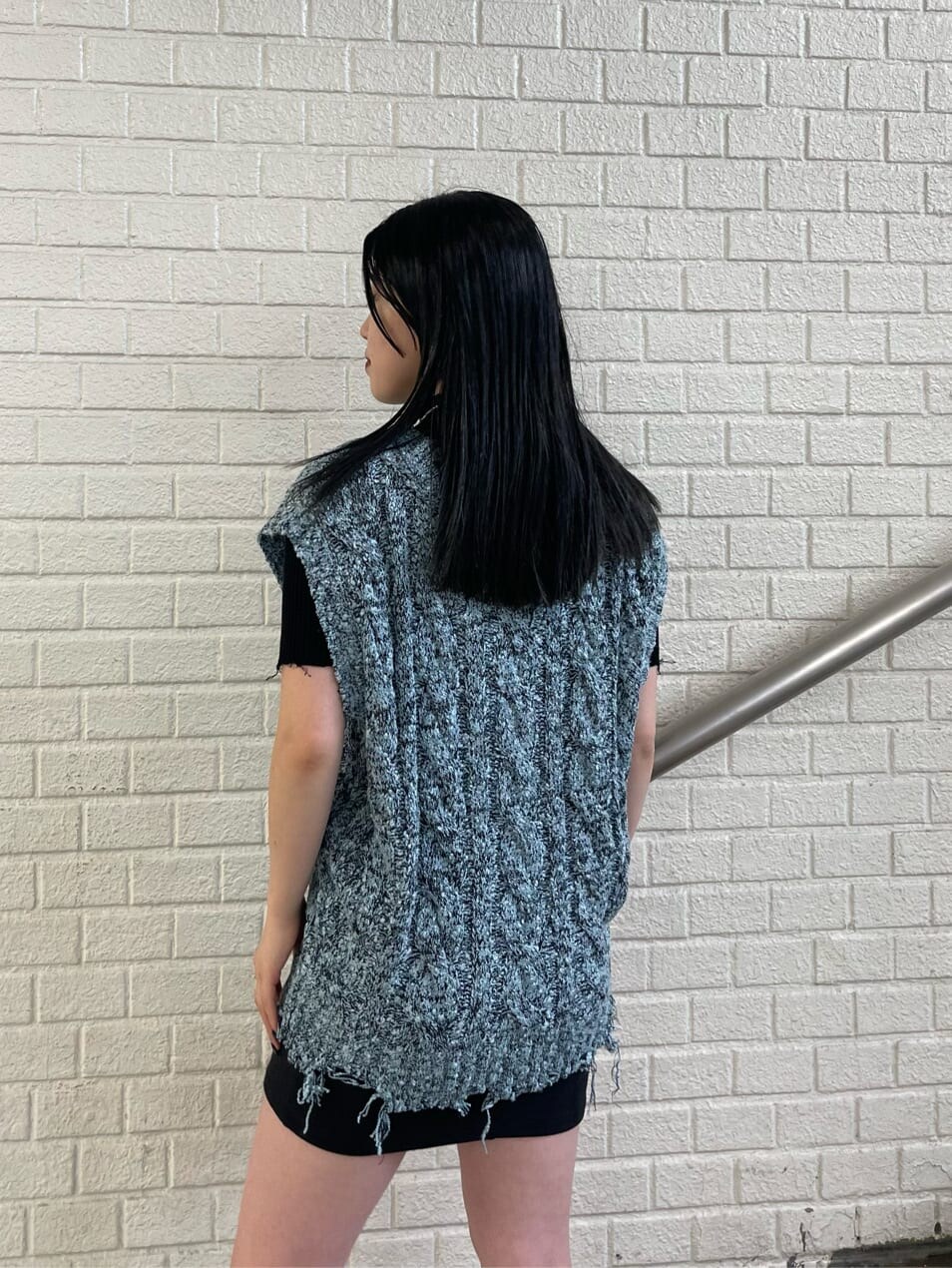 ブラック系のスカート、ブラック系のブーツ、ブラック系のニット/セーターを着用したレディースの夏コーディネートの5枚目の写真