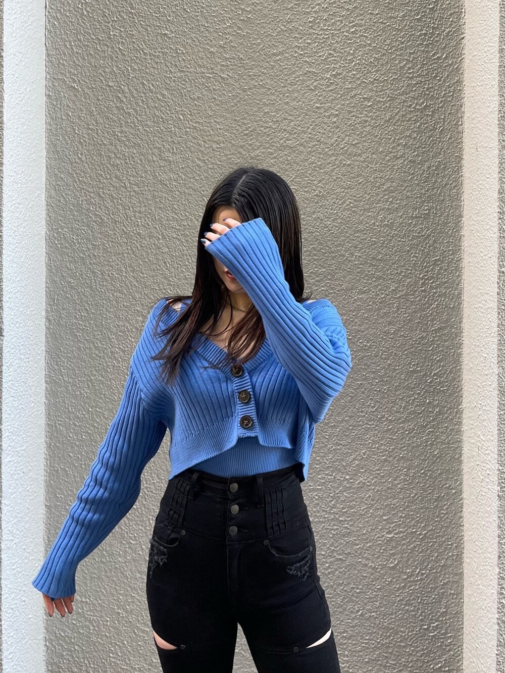 ブラック系のデニムパンツ、ブルー系のカーディガン/ボレロ、ブラック系のブーツを着用したレディースの冬コーディネートの4枚目の写真