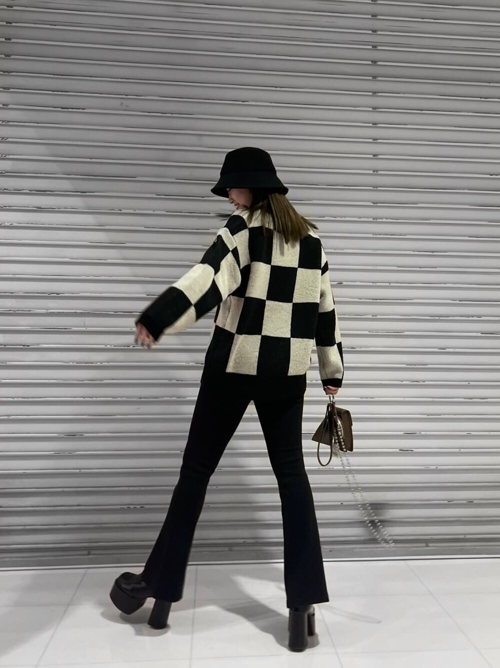 ブラック系のその他パンツ、ブラック系のローファー、ブラウン系のハンドバッグを着用したレディースの冬コーディネートの2枚目の写真