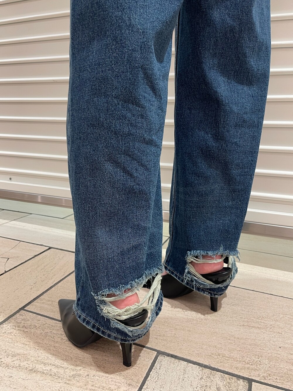 ベージュ系のブルゾン、ホワイト系のキャミソール、ブルー系のデニムパンツを着用したレディースの冬コーディネートの4枚目の写真