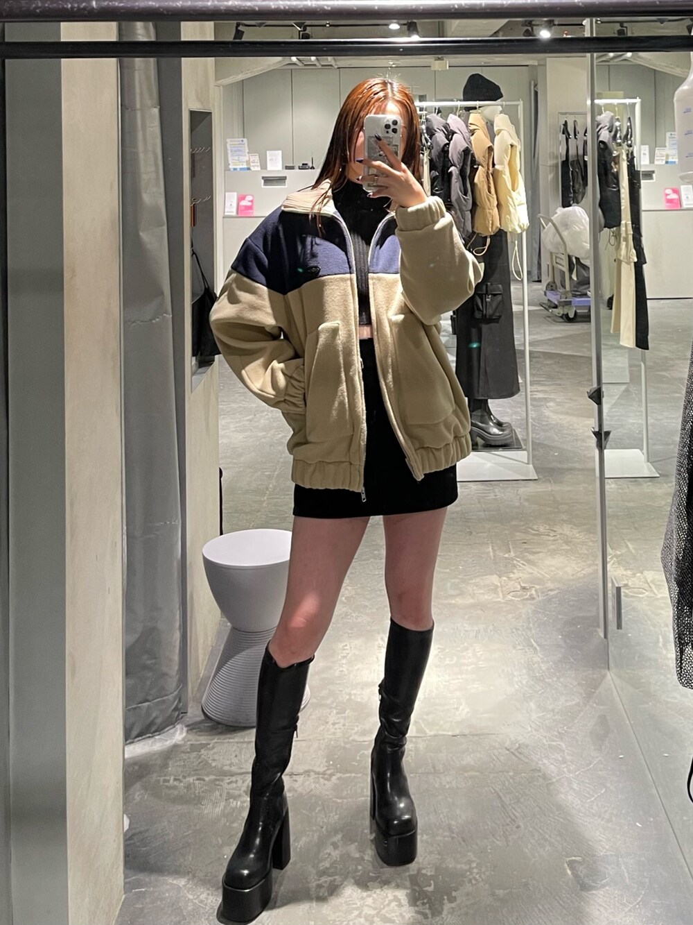 ブルー系のブルゾン、ブラック系のスカート、ブラック系のブーツを着用したレディースの秋コーディネートの5枚目の写真