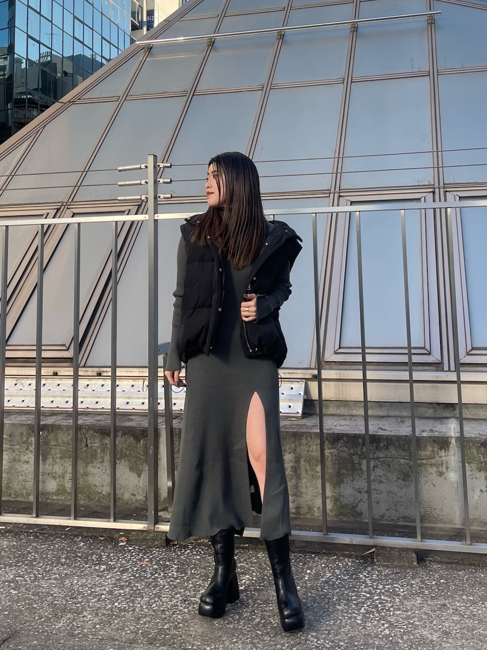 ブラック系のダウンジャケット/コート、グレー系のワンピース、ブラック系のブーツを着用したレディースの秋コーディネートの2枚目の写真