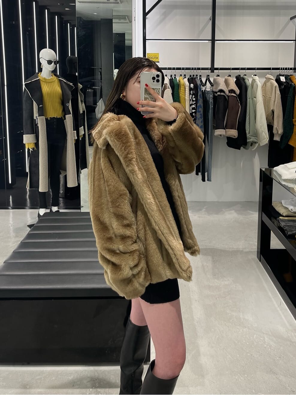 ブラック系のワンピース、ベージュ系のその他アウター、ブラック系のブーツを着用したレディースの冬コーディネートの6枚目の写真