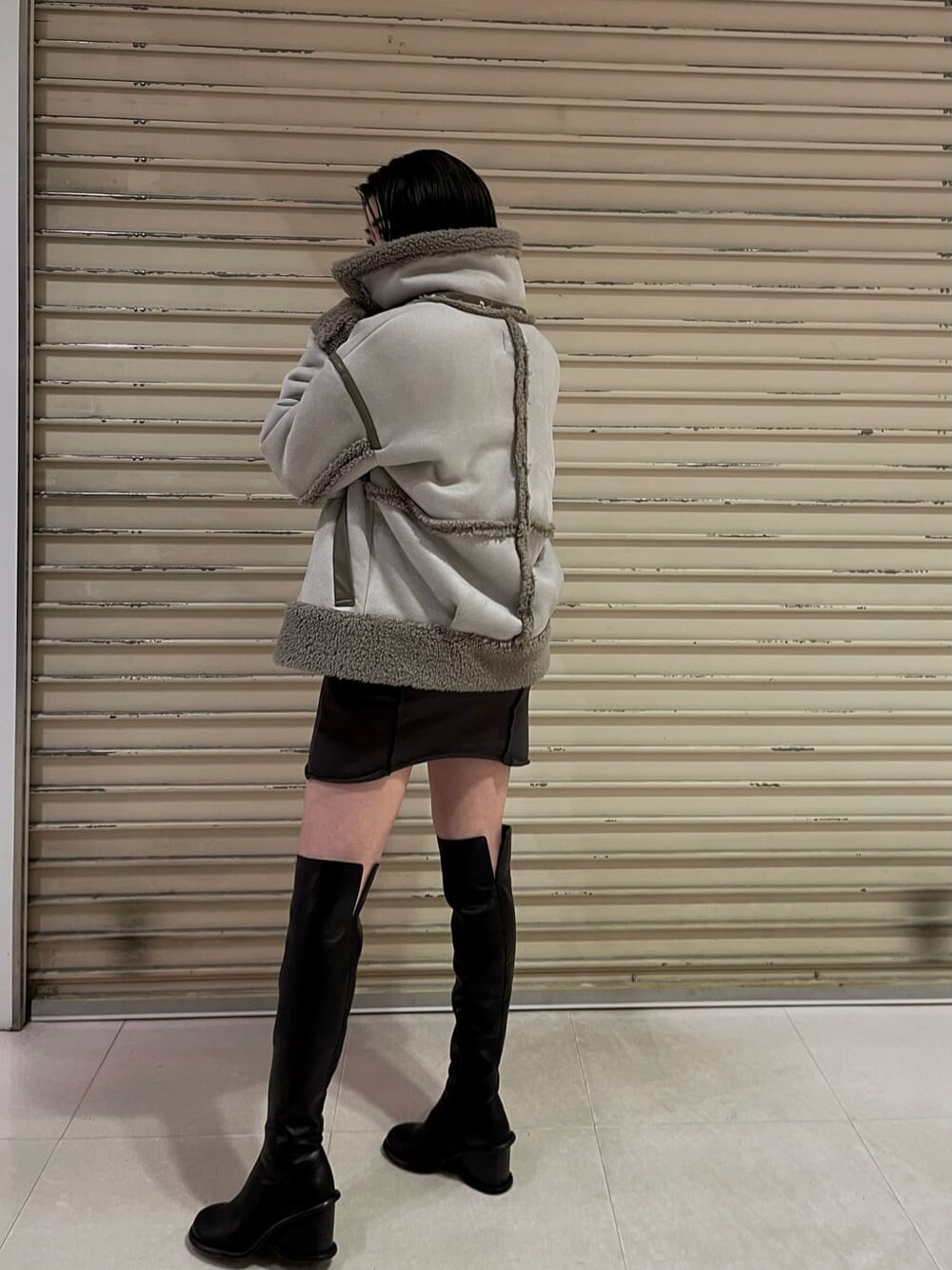 ブラック系のブーツ、グレー系のワンピース、グレー系のムートンコートを着用したレディースの秋コーディネートの7枚目の写真