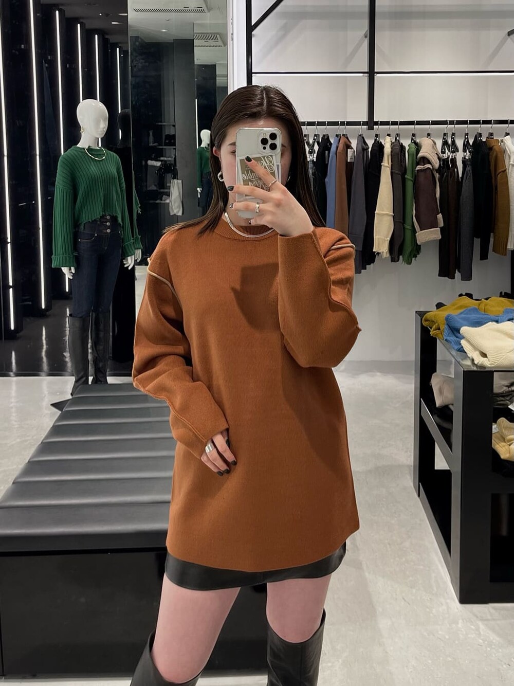 オレンジ系のニット/セーター、ブラック系のブーツを着用したレディースの秋コーディネートの3枚目の写真