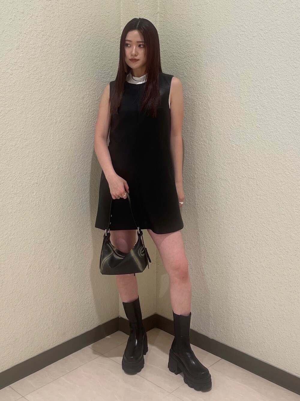 ブラック系のワンピース、ホワイト系のタンクトップ、ブラック系のブーツを着用したレディースの夏コーディネートの2枚目の写真