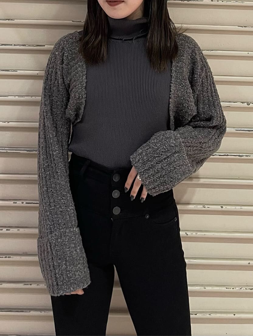 ブラック系のデニムパンツ、ブラック系のブーツ、グレー系のニット/セーターを着用したレディースの秋コーディネートの3枚目の写真