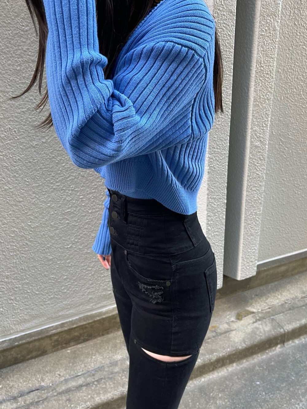 ブラック系のデニムパンツ、ブルー系のカーディガン/ボレロ、ブラック系のブーツを着用したレディースの冬コーディネートの5枚目の写真