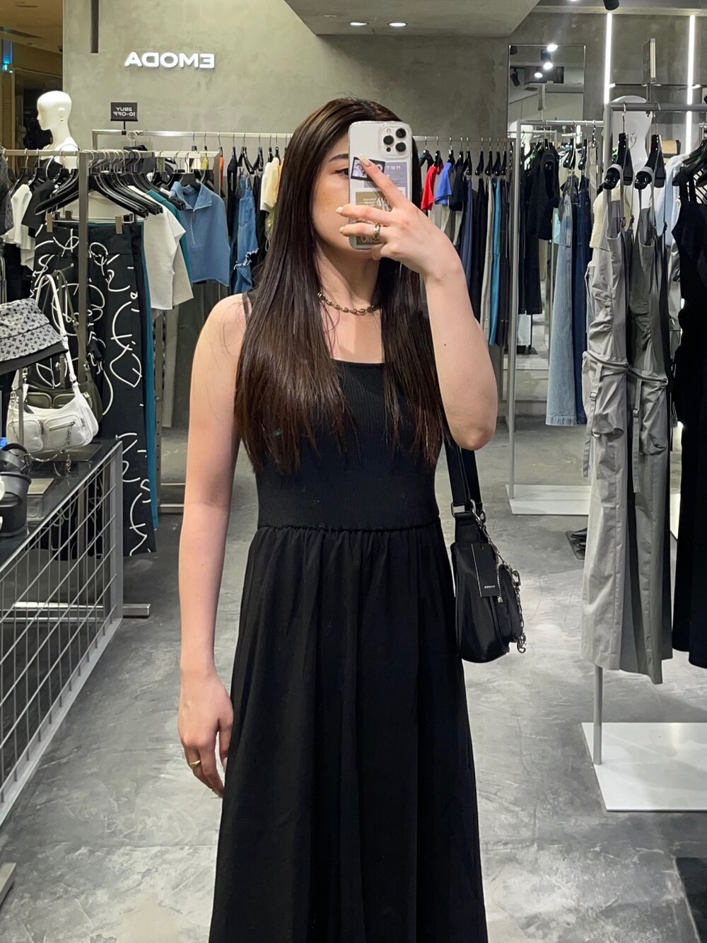 ブラック系のワンピース、ホワイト系のブーツ、ブラック系のハンドバッグを着用したレディースの夏コーディネートの3枚目の写真