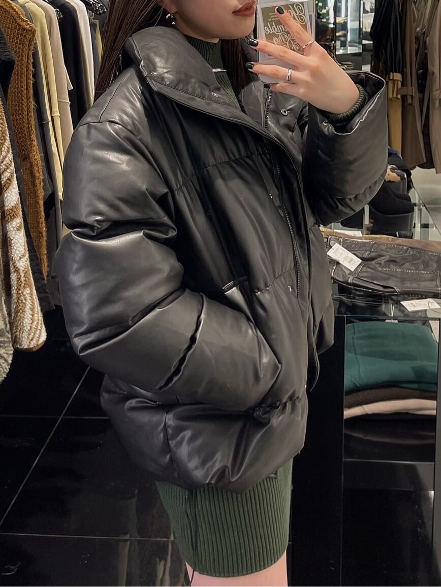 グリーン系のワンピース、ブラック系のブーツ、その他のダウンジャケット/コートを着用したレディースの秋コーディネートの2枚目の写真