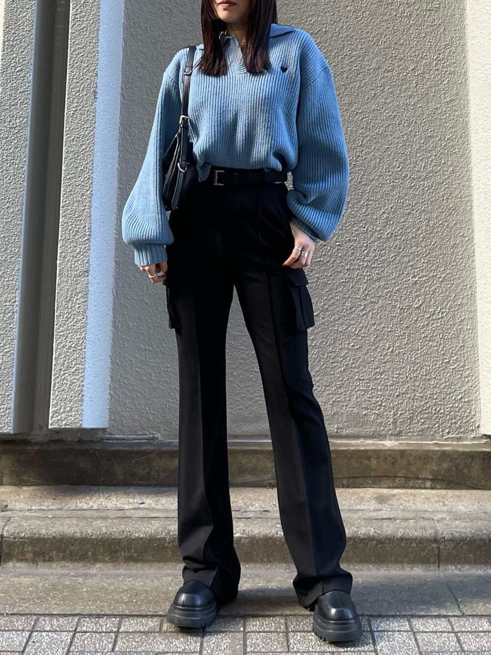 ブルー系のニット/セーター、ブラック系のカーゴパンツ、ブラック系のブーツを着用したレディースの冬コーディネートの4枚目の写真