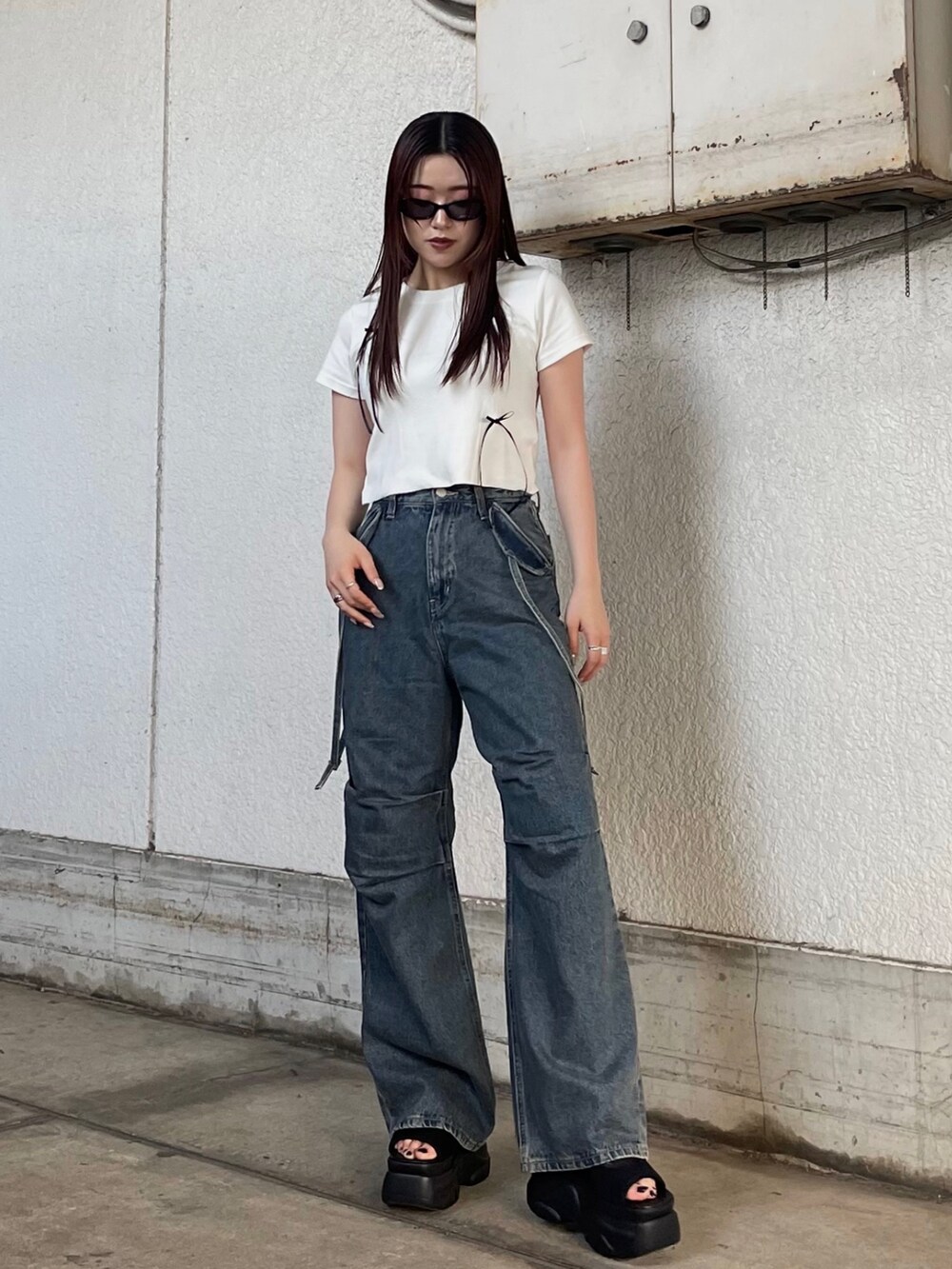 ホワイト系のTシャツ/カットソー、ブラック系のサンダル、ブルー系のデニムパンツを着用したレディースの夏コーディネートの2枚目の写真