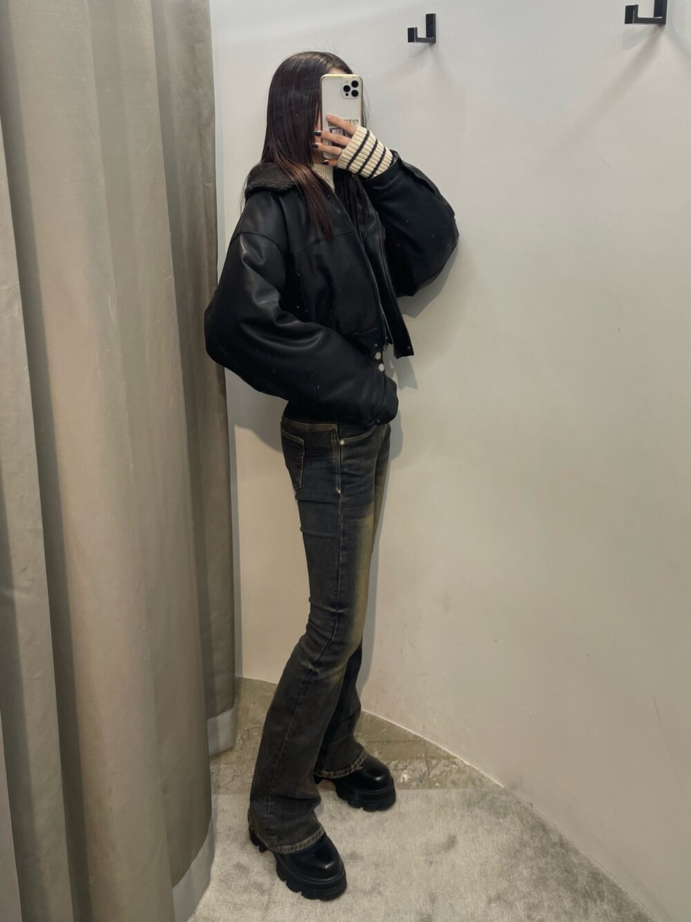 ブルー系のデニムパンツ、ホワイト系のニット/セーター、ブラック系のブルゾンを着用したレディースの秋コーディネートの2枚目の写真