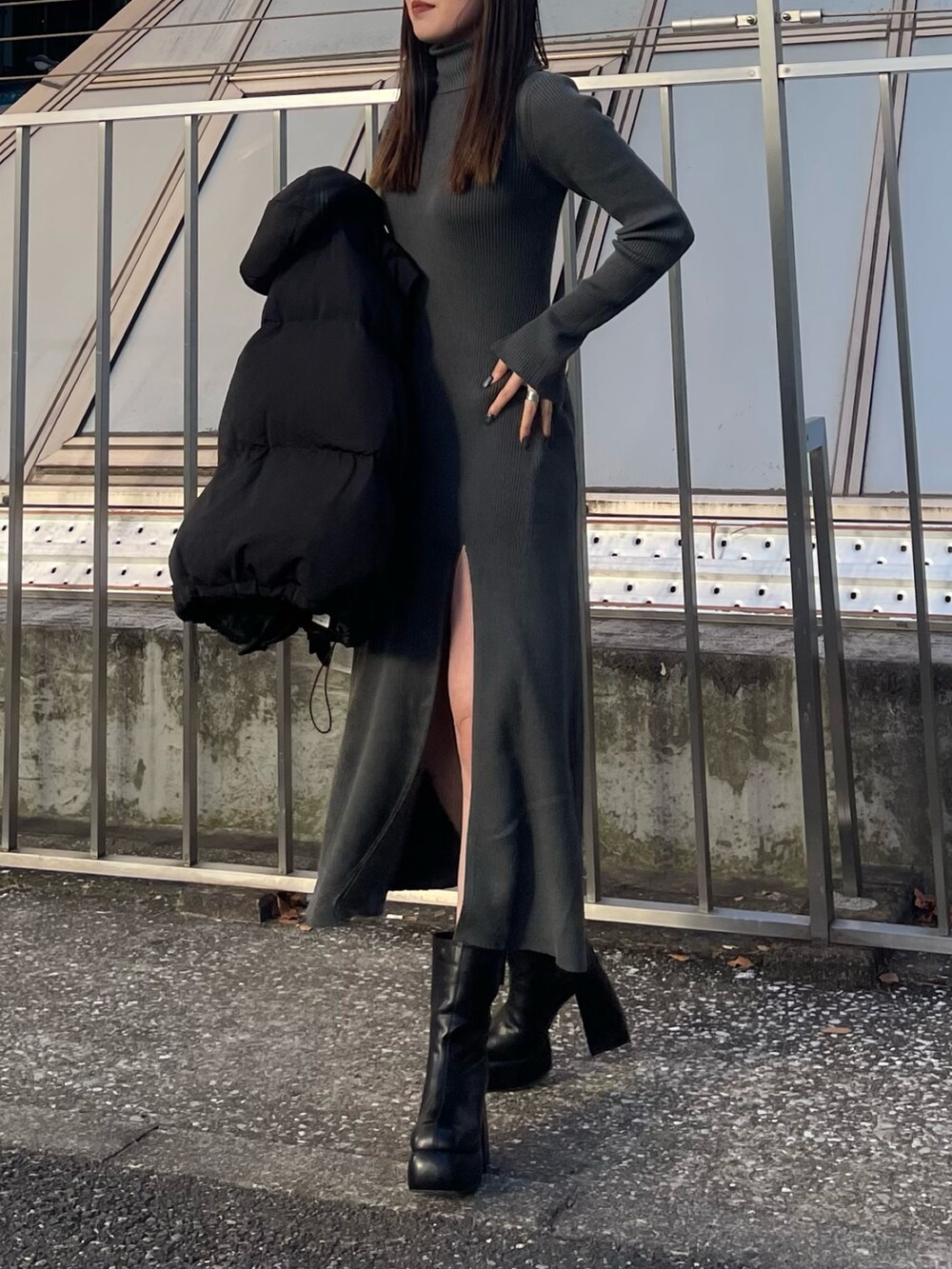 ブラック系のダウンジャケット/コート、グレー系のワンピース、ブラック系のブーツを着用したレディースの秋コーディネートの4枚目の写真