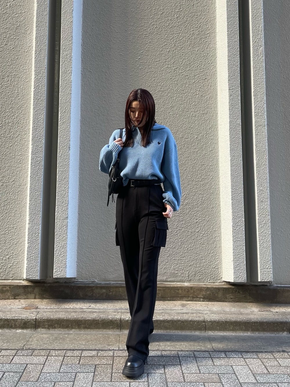 ブルー系のニット/セーター、ブラック系のカーゴパンツ、ブラック系のブーツを着用したレディースの冬コーディネートの2枚目の写真