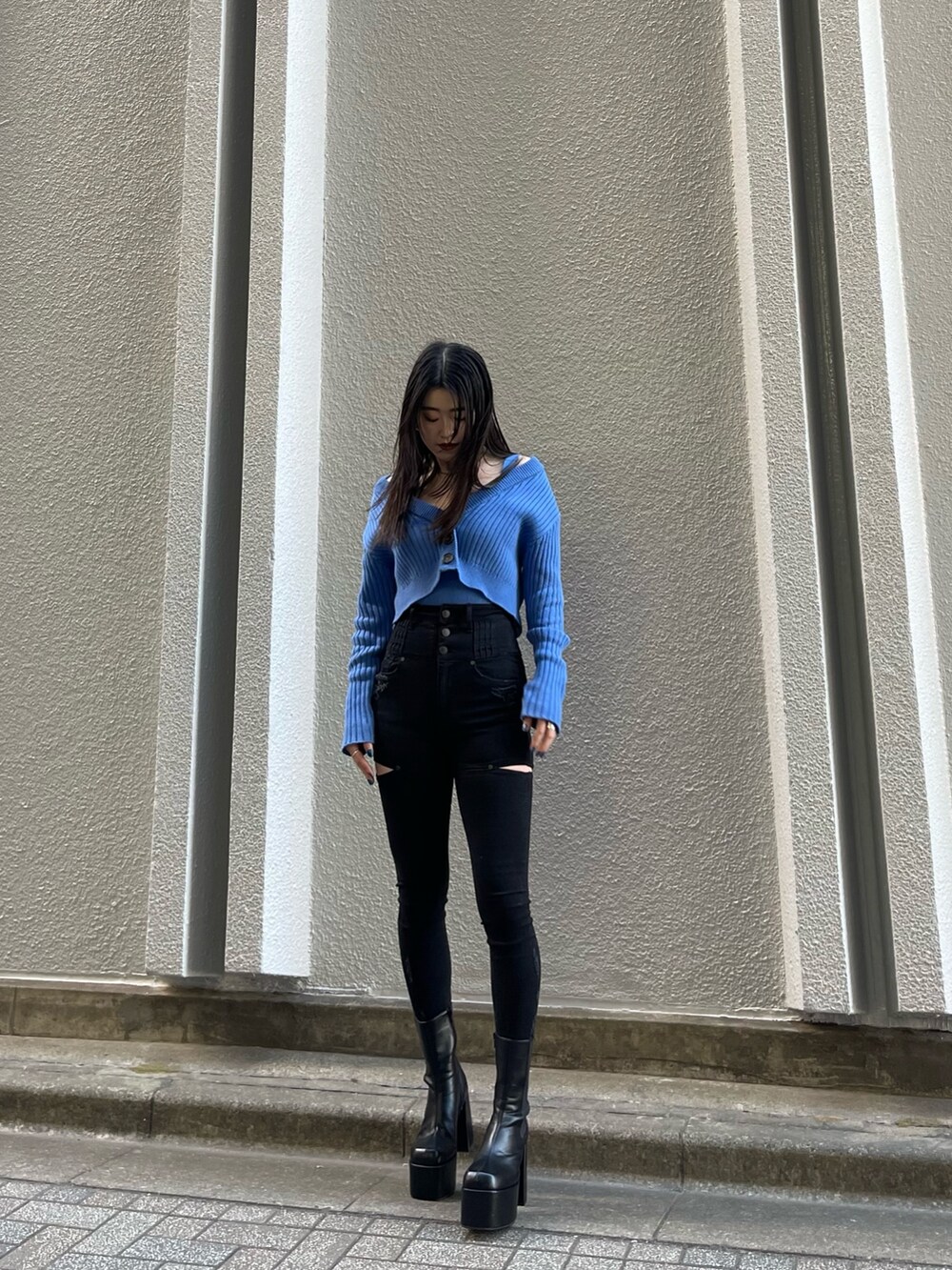 ブラック系のデニムパンツ、ブルー系のカーディガン/ボレロ、ブラック系のブーツを着用したレディースの冬コーディネートの2枚目の写真
