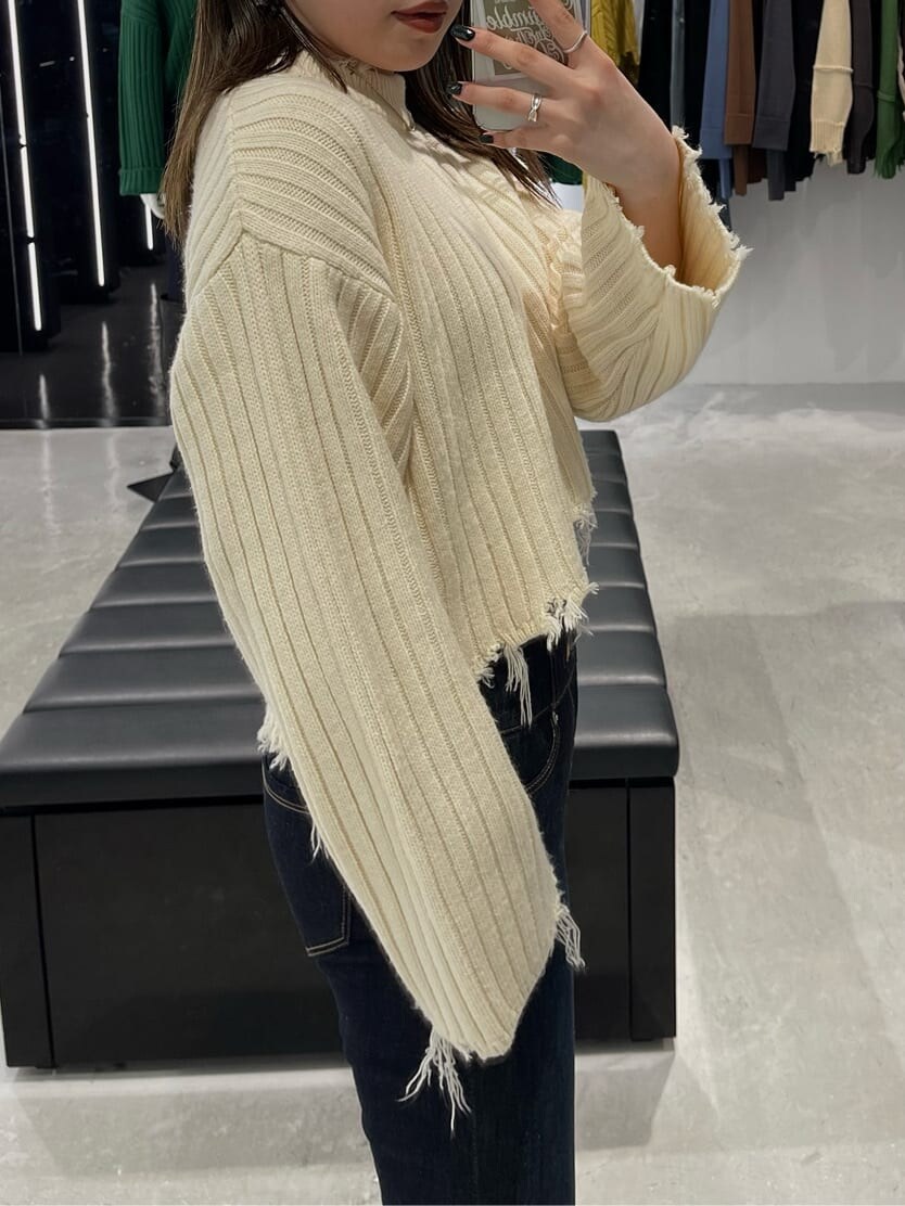 ブルー系のデニムパンツ、ブラック系のブーツ、ホワイト系のニット/セーターを着用したレディースの秋コーディネートの2枚目の写真