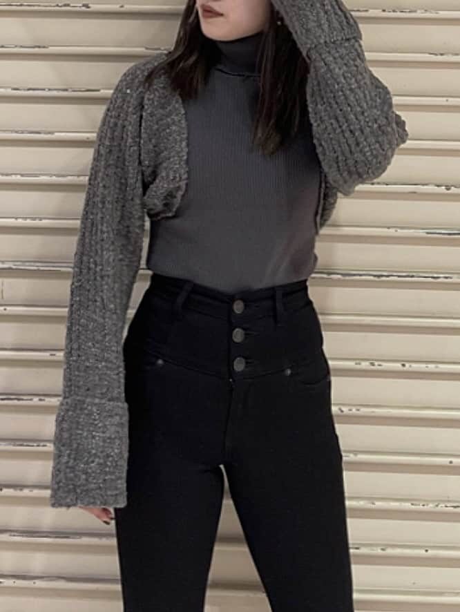 ブラック系のデニムパンツ、ブラック系のブーツ、グレー系のニット/セーターを着用したレディースの秋コーディネートの2枚目の写真