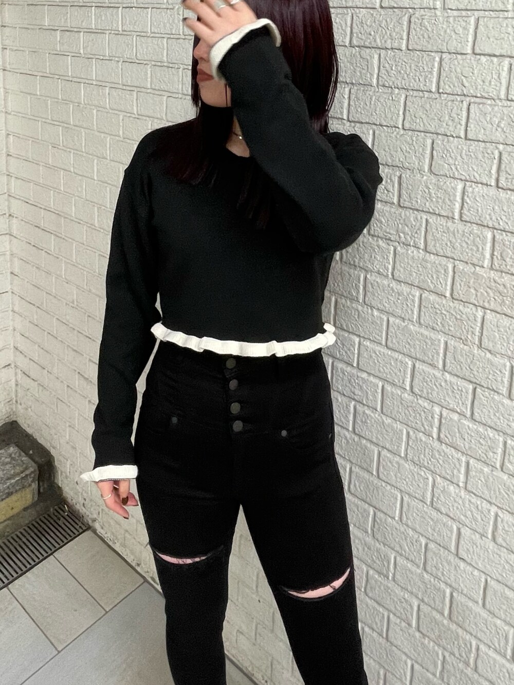 ブラック系のニット/セーター、ブラック系のデニムパンツ、ブラック系のブーツを着用したレディースの冬コーディネートの4枚目の写真