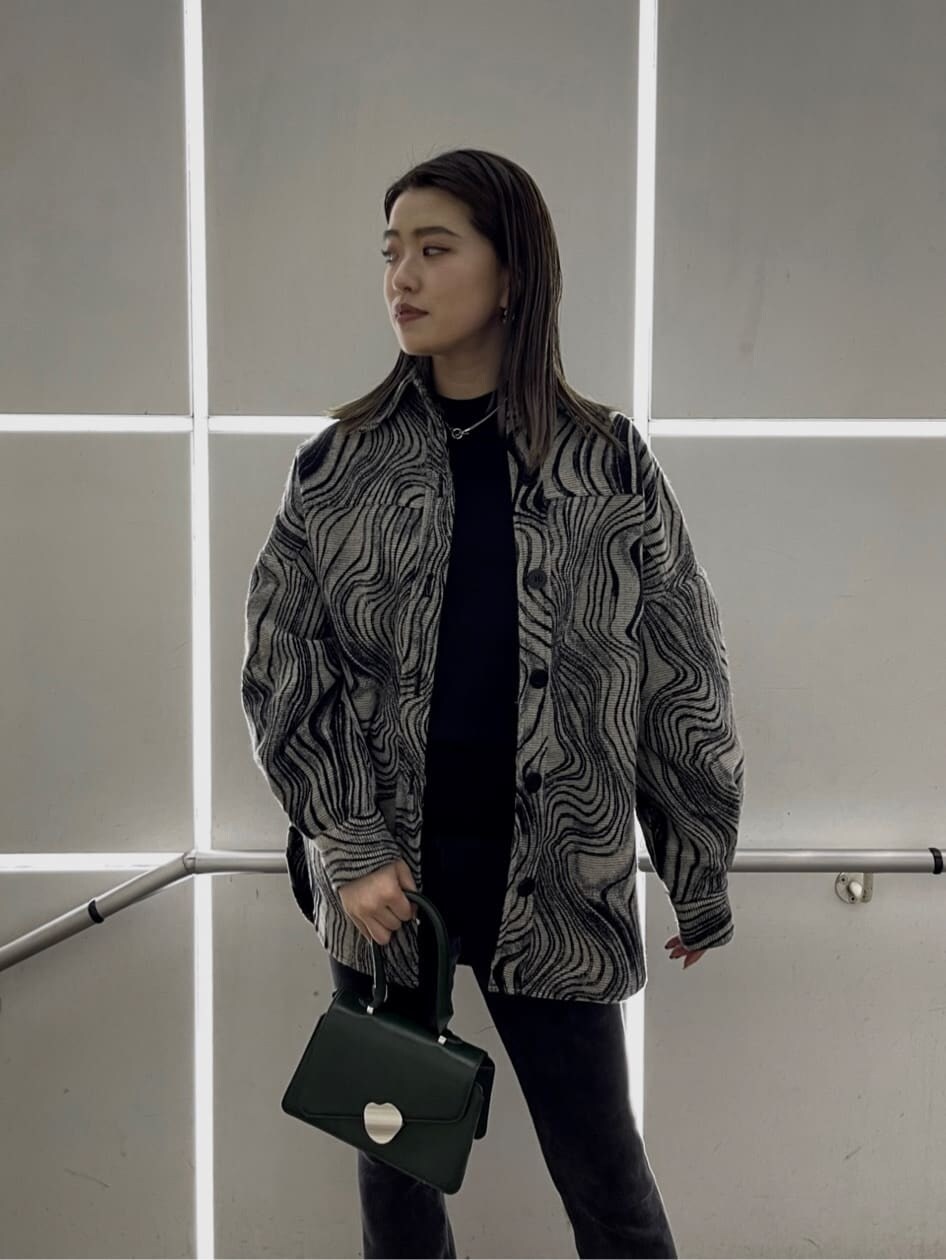 ブラック系のローファー、グリーン系のハンドバッグ、ブラック系のニット/セーターを着用したレディースの秋コーディネートの5枚目の写真