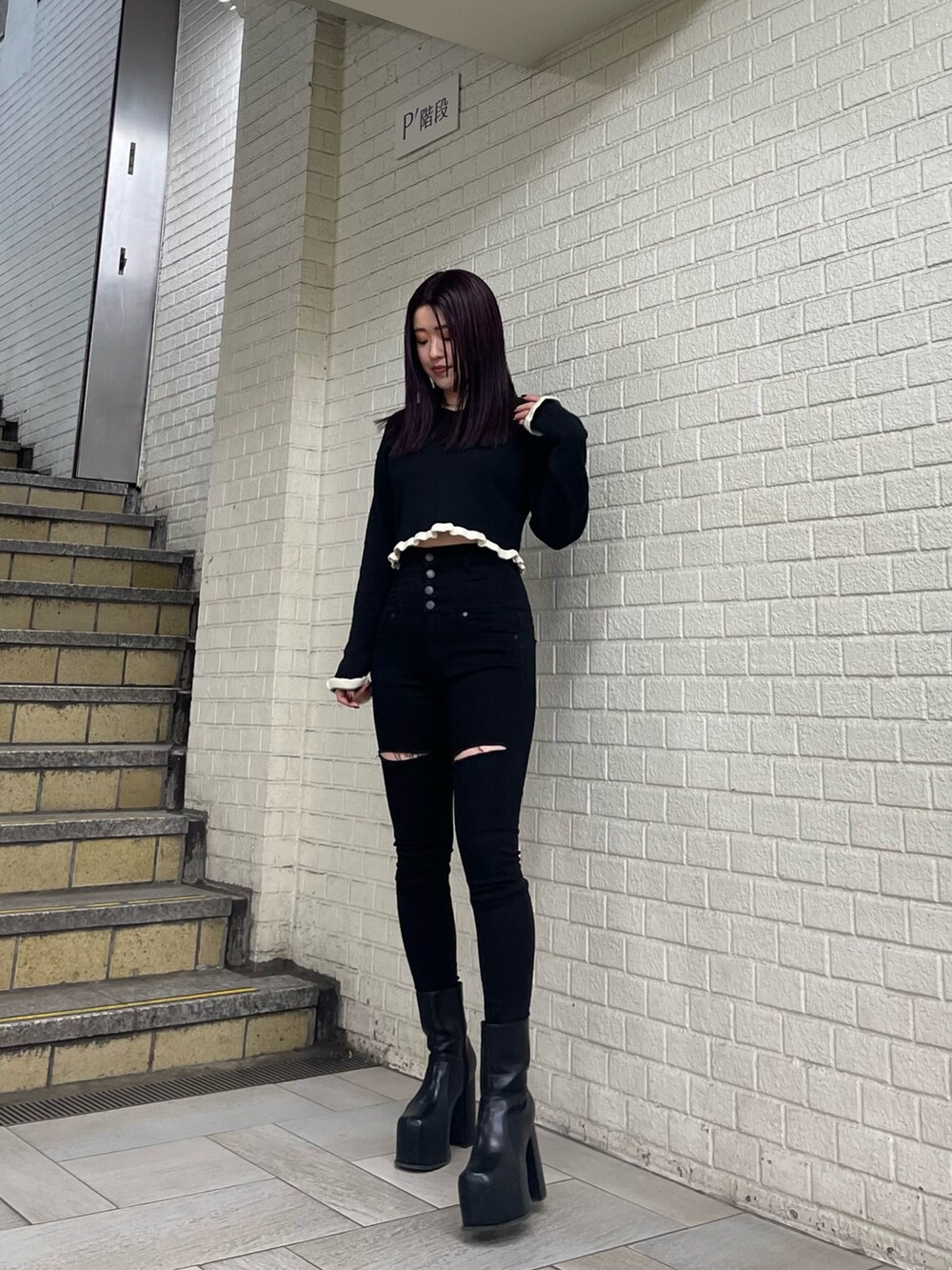 ブラック系のニット/セーター、ブラック系のデニムパンツ、ブラック系のブーツを着用したレディースの冬コーディネートの3枚目の写真