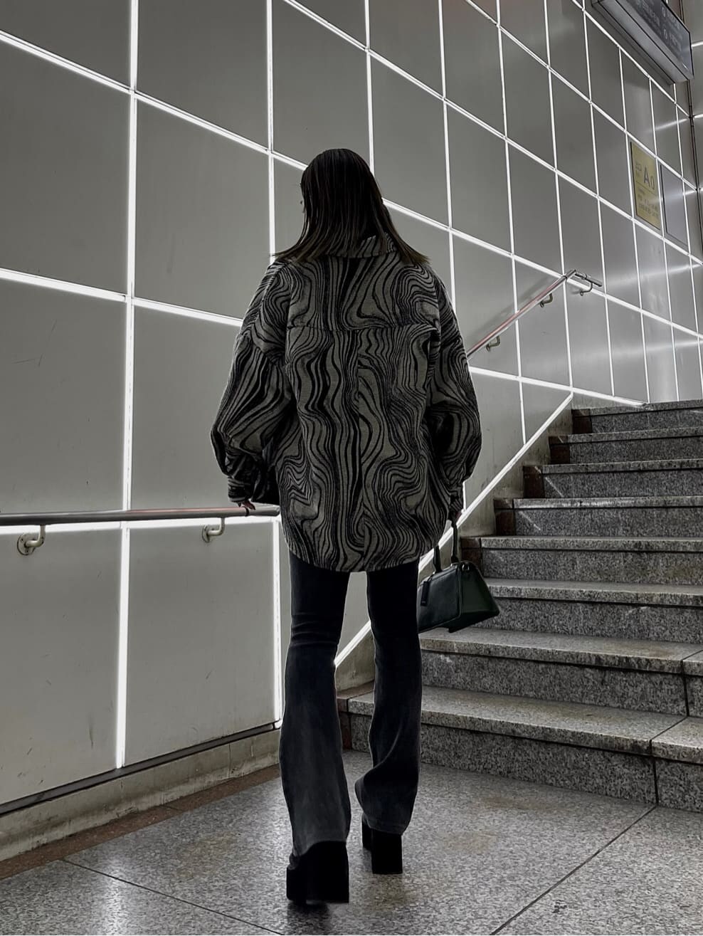 ブラック系のローファー、グリーン系のハンドバッグ、ブラック系のニット/セーターを着用したレディースの秋コーディネートの4枚目の写真