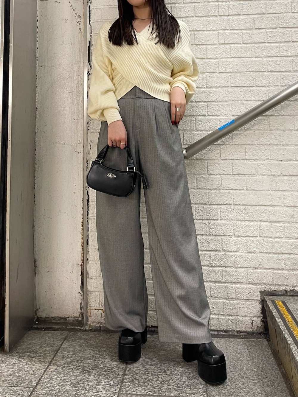 ホワイト系のニット/セーター、グレー系のその他パンツ、ブラック系のブーツを着用したレディースの冬コーディネートの2枚目の写真