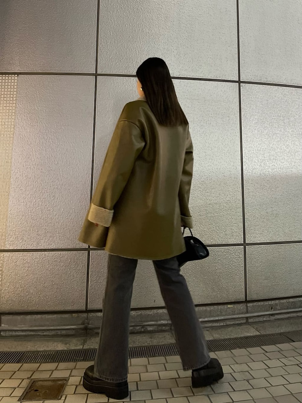 ブラック系のハンドバッグ、ベージュ系のムートンコート、ホワイト系のニット/セーターを着用したレディースの冬コーディネートの6枚目の写真