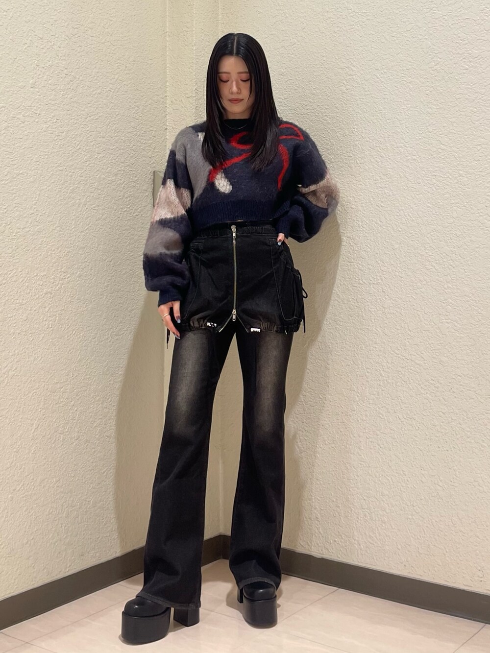 ブラック系のデニムパンツ、ブルー系のニット/セーター、ブラック系のブーツを着用したレディースの秋コーディネートの3枚目の写真